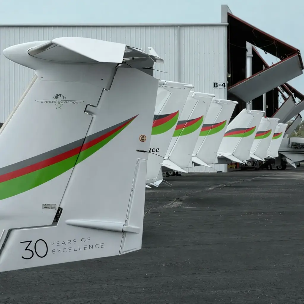 Cirrus Aviation aircraft fleet tails lined up besides a hangar