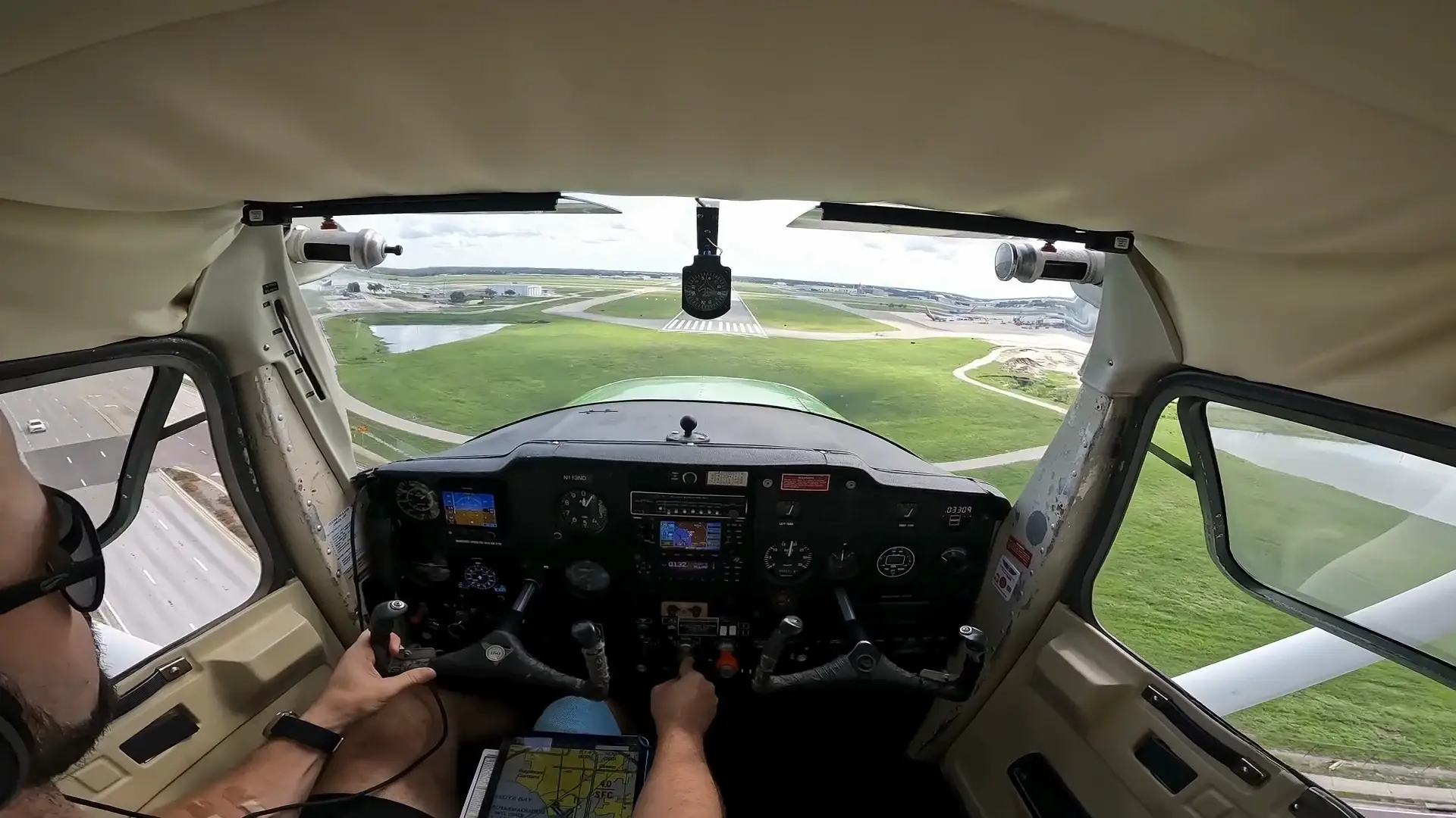 Airplane landing on runway seen from pilot over the shoulder view
