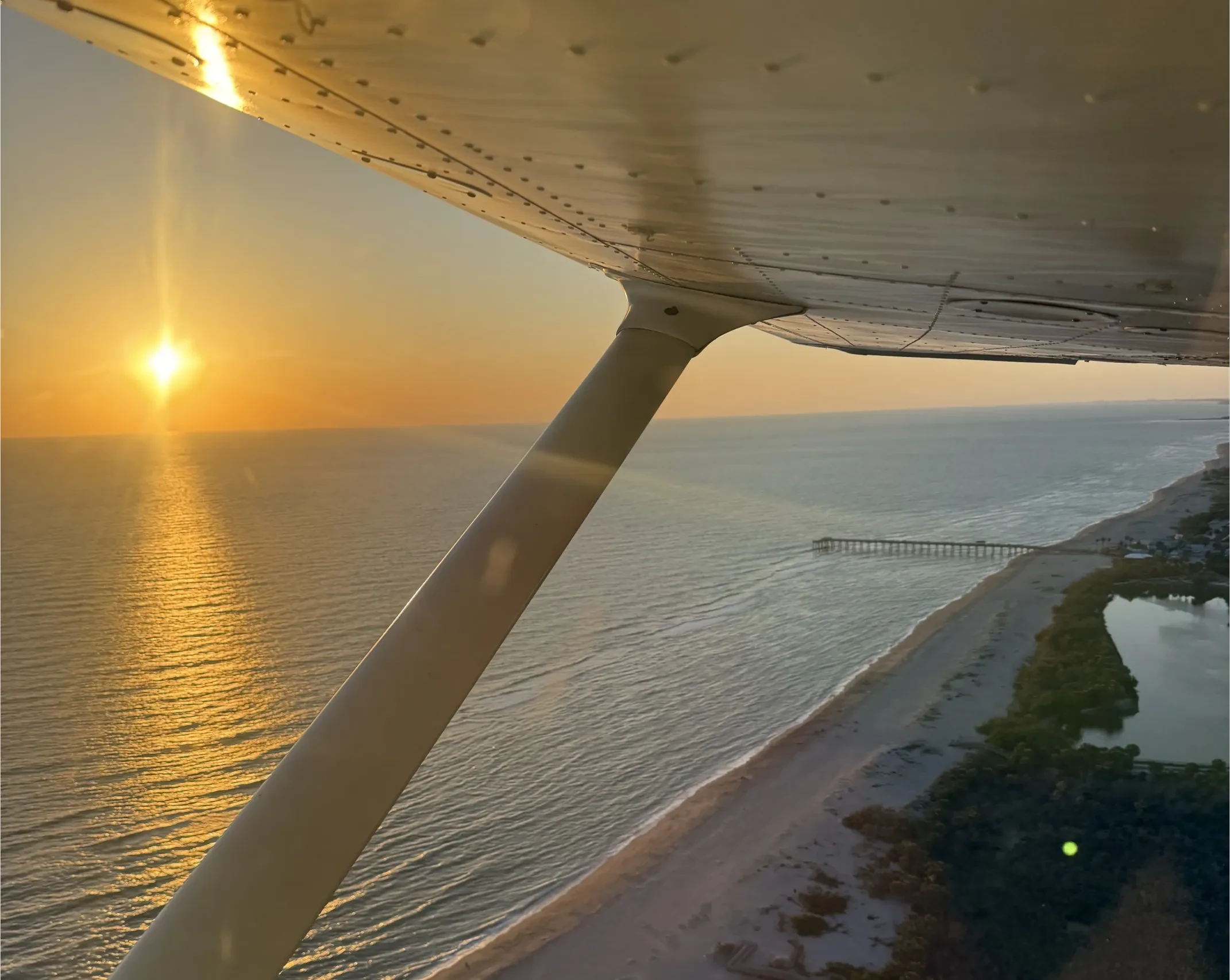Airport runway with planes in sight and the sunset in the horizon