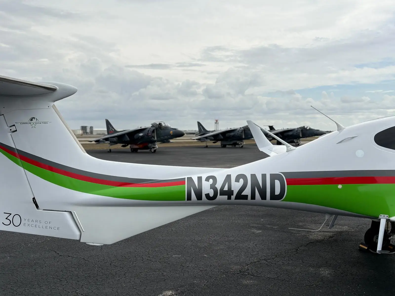 Cirrus Aviation aircraft tail N342ND with dark jet aircraft in the background