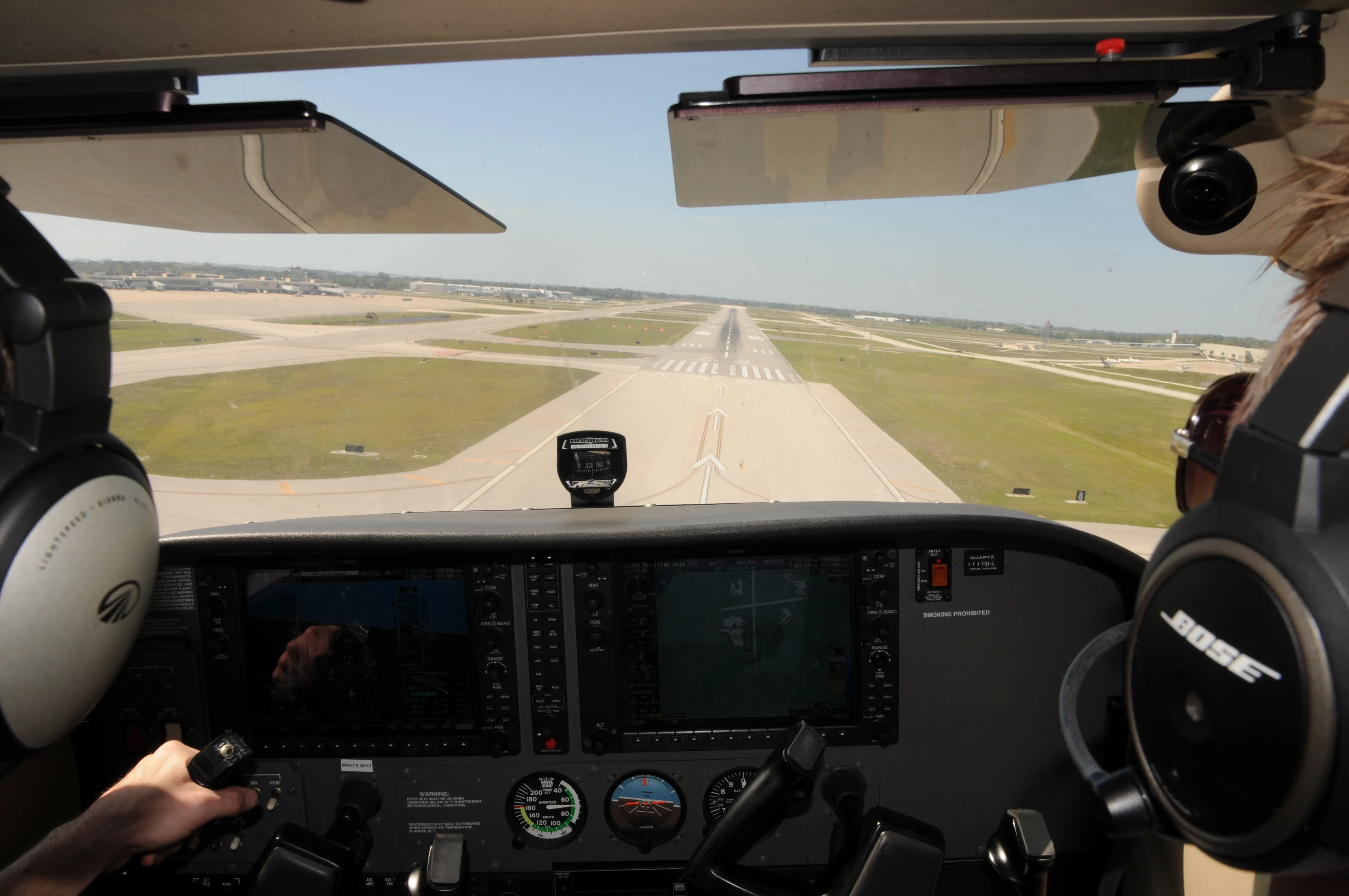 View from inside and airplane of two pilots almost landing with the runway close in sight
