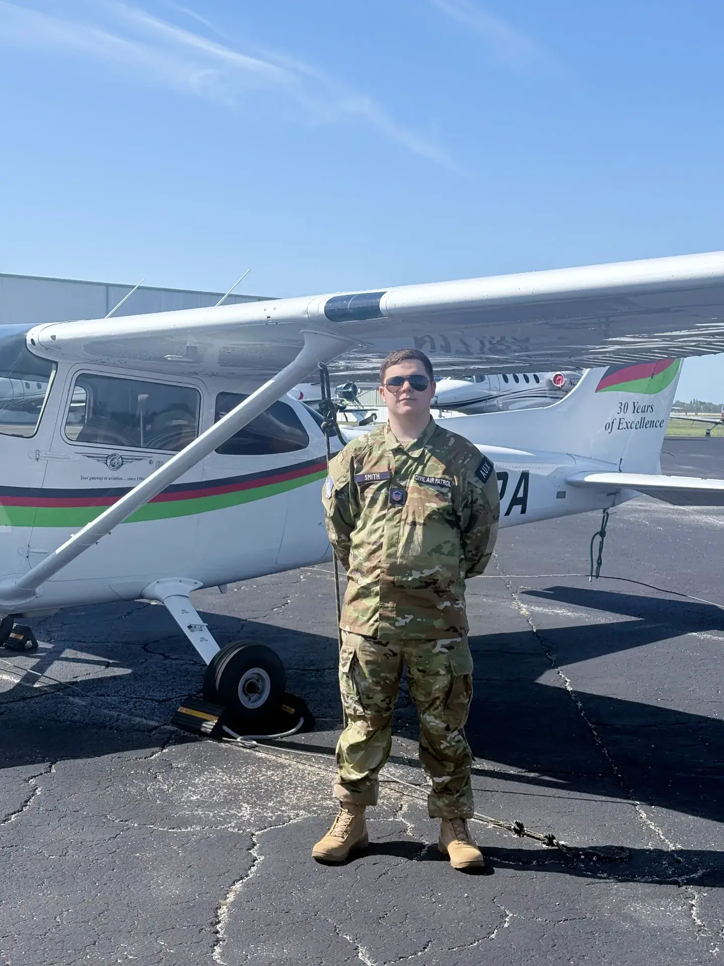 Man in military uniform in front of Cessna 172 Skyhawk airplane