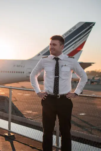 Pilot standing next to an airplane's tail