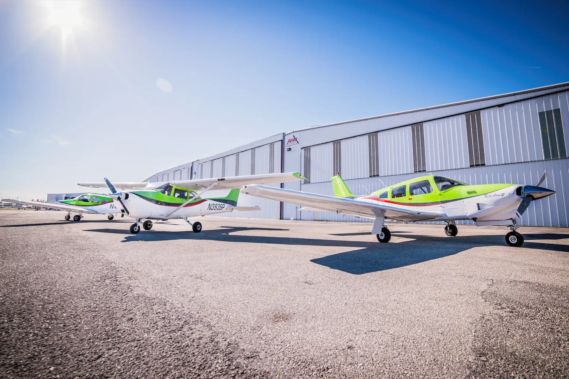 Three airplanes in front of hangars