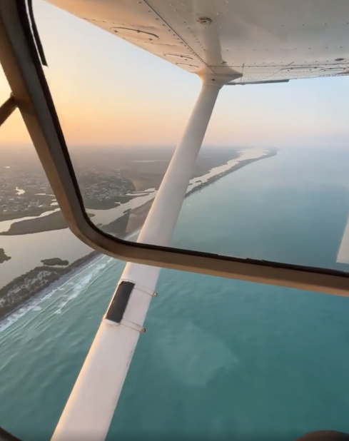 View of the sea and land in Sarasota, Florida from an airplane's open window