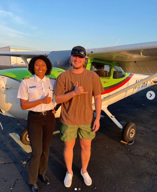 Student and CFI smiling at the camera in front of a Cessna aircraft
