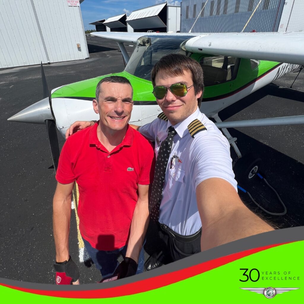 Student and CFI standing in front of a Cessna aircraft, high angle, Cirrus Aviation watermark at the bottom of the image