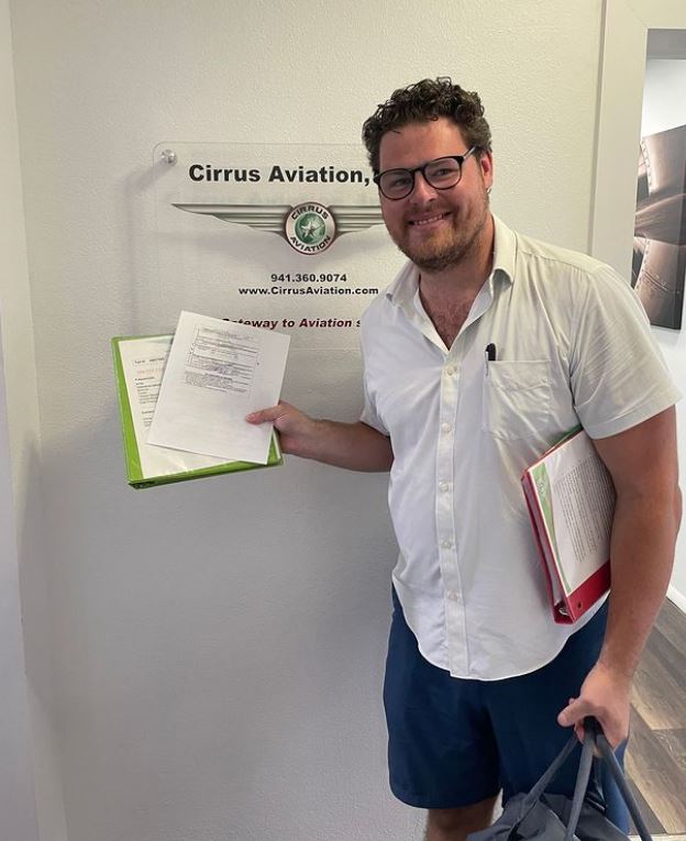 Student smiling at the camera inside Cirrus Aviation's office