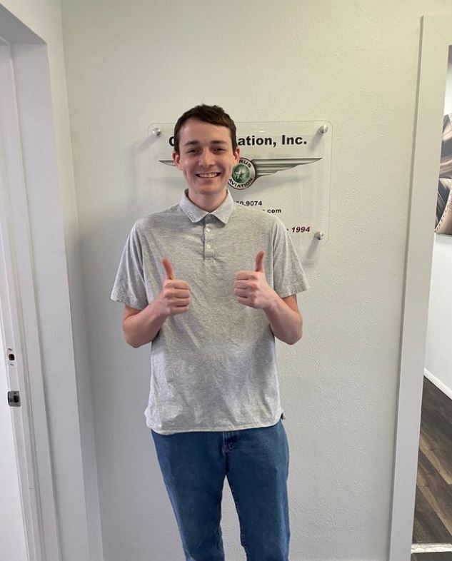 Student with his thumbs up smiling to the camera