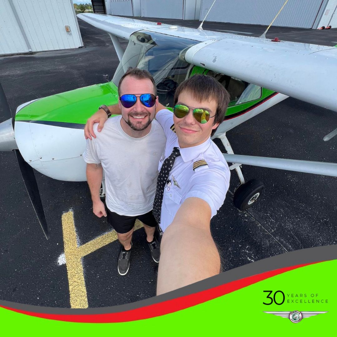Student and CFI standing in front of a Cessna aircraft, high angle, Cirrus Aviation watermark at the bottom of the image