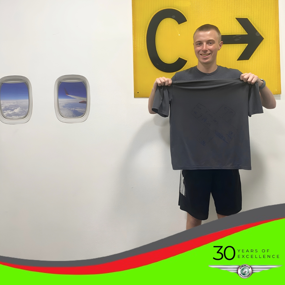 Student holding t-shirt with First Solo written on it, Cirrus Aviation watermark at the bottom of the image