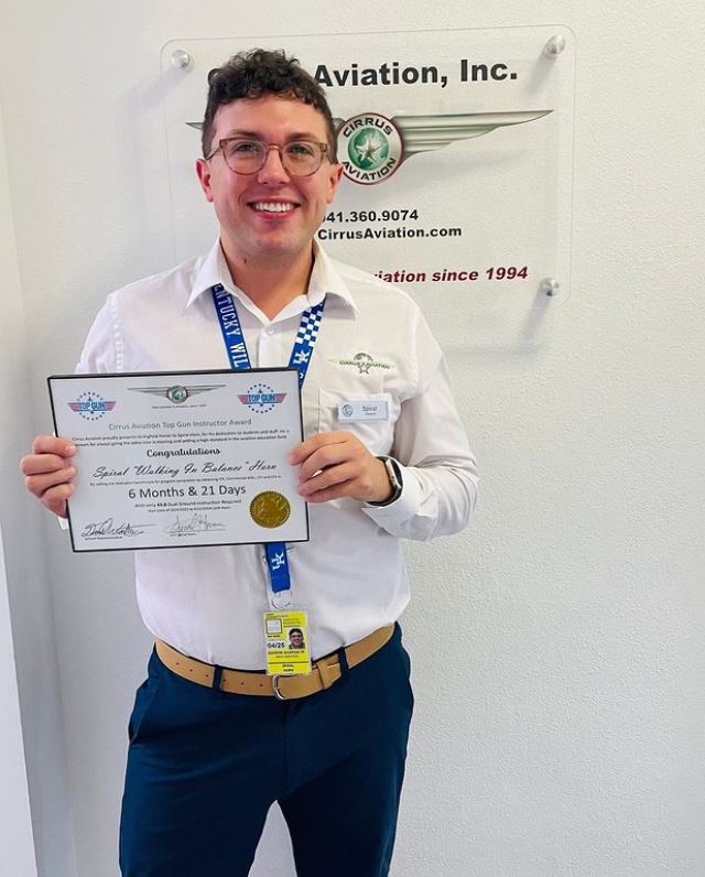 Man holding certificate and smiling at the camera