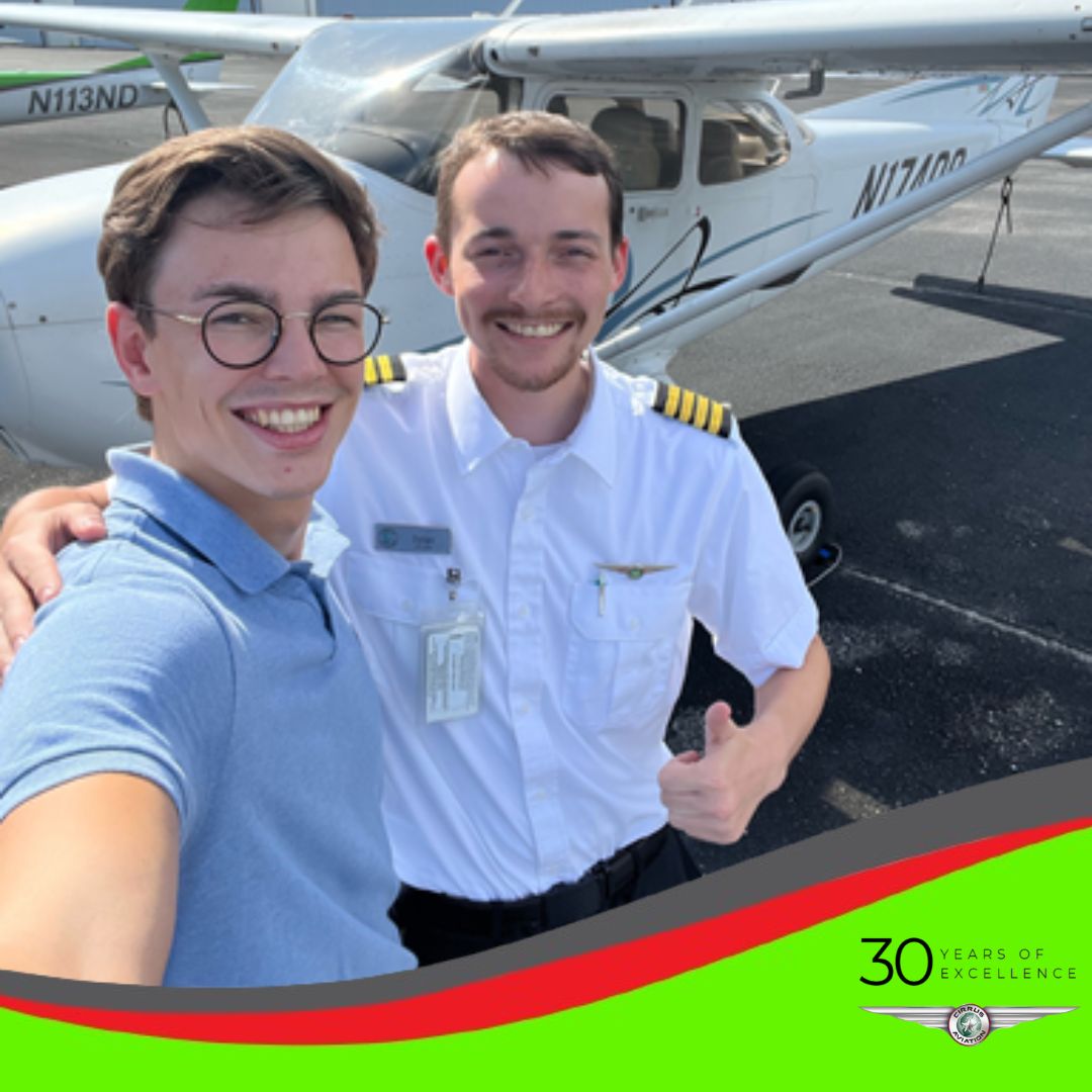 Student and CFI standing in front of a Cessna aircraft, high angle, Cirrus Aviation watermark at the bottom of the image