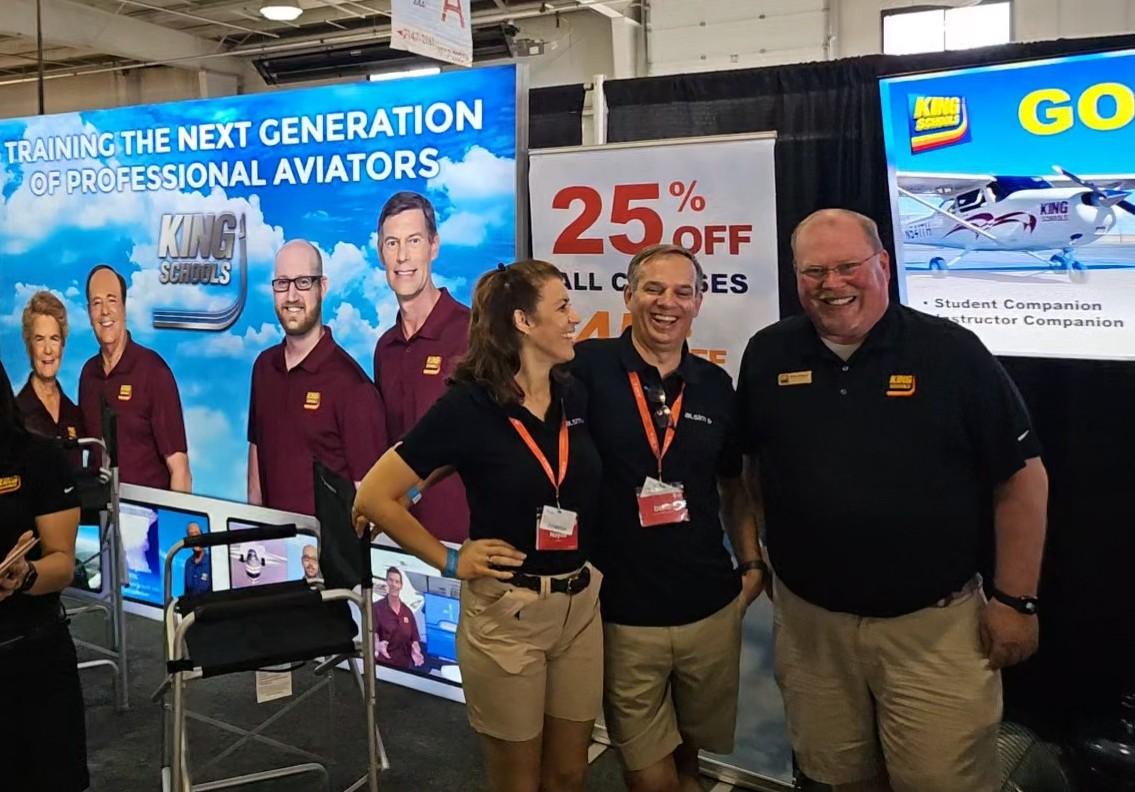 Cirrus Aviation owners Nayda and David Cattin with Brian Hough at the King Schools booth, EAA AirVenture Oshkosh 2024