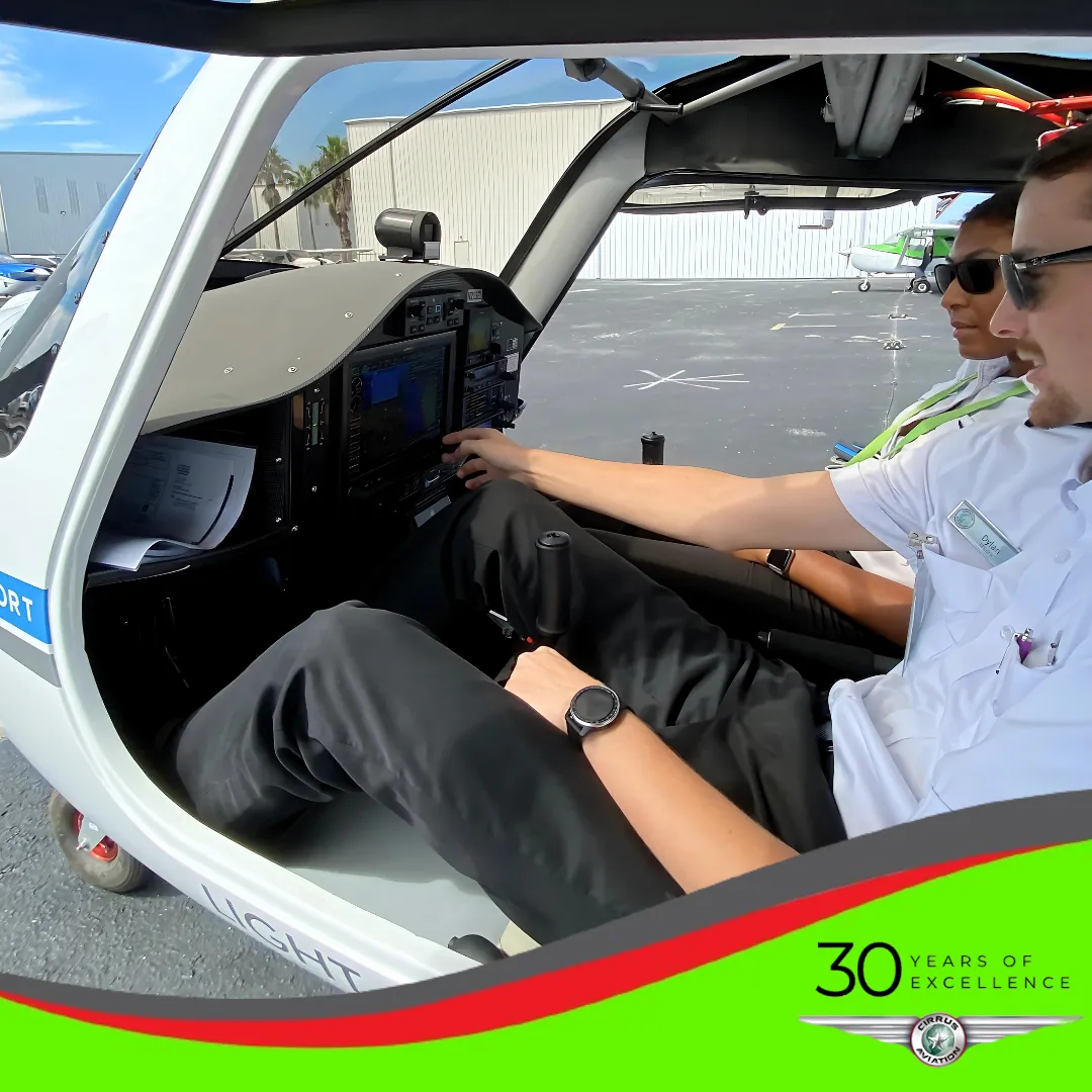 Two pilots inside aircraft cockpit seen from the left open door